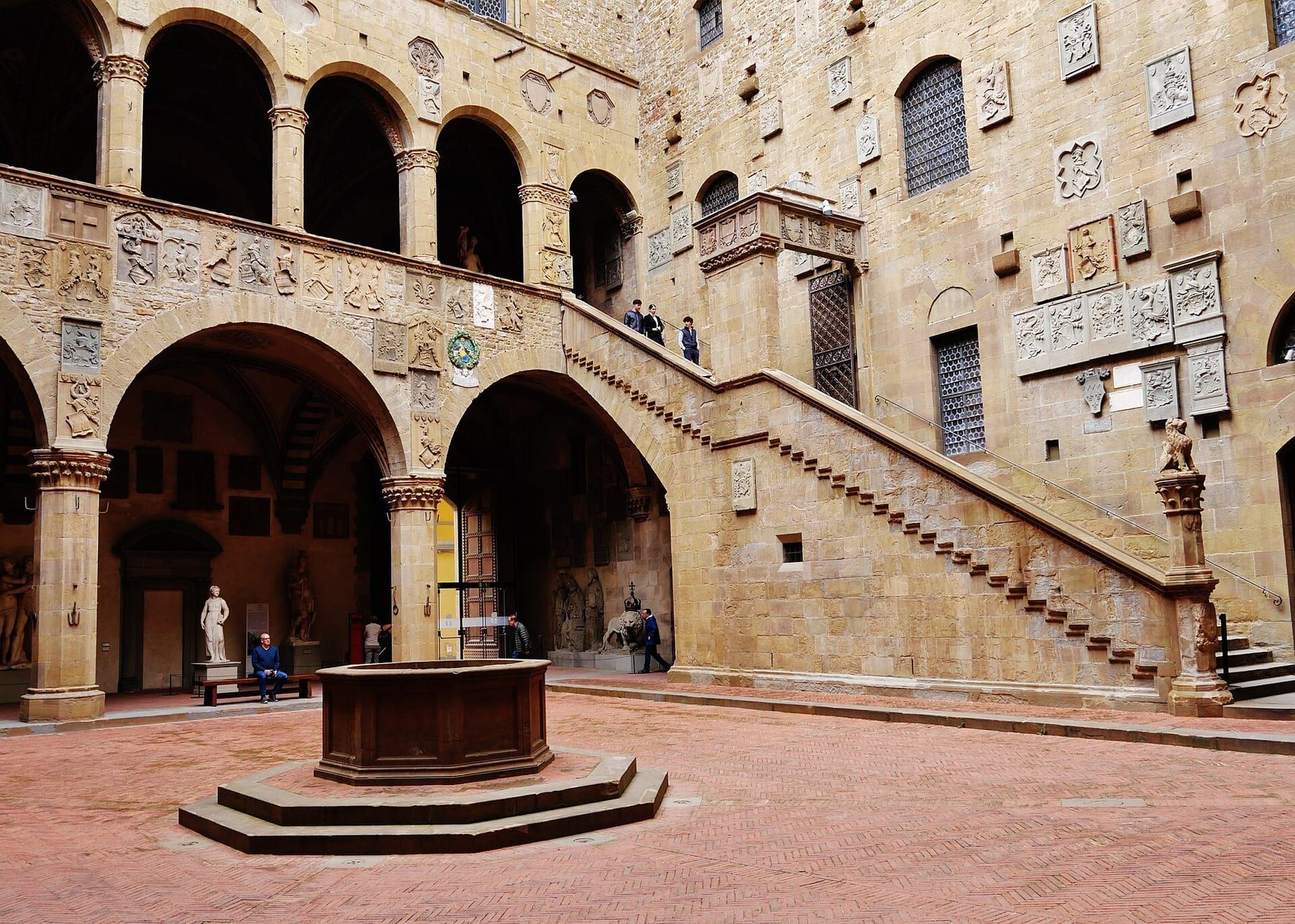 Il cortile del Bargello con il loggiato, lo scalone coperto e gli stemmi in pietra sulle pareti